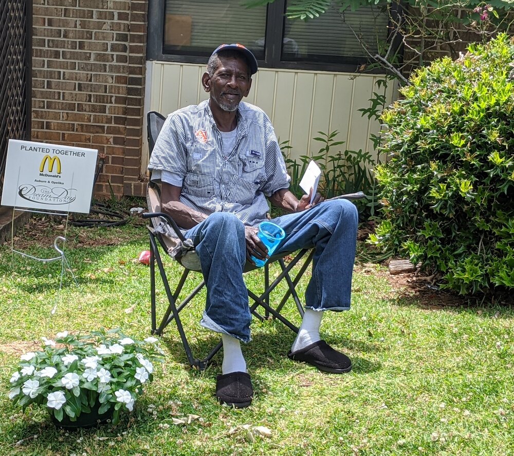 planted together resident  man sitting outside in chair