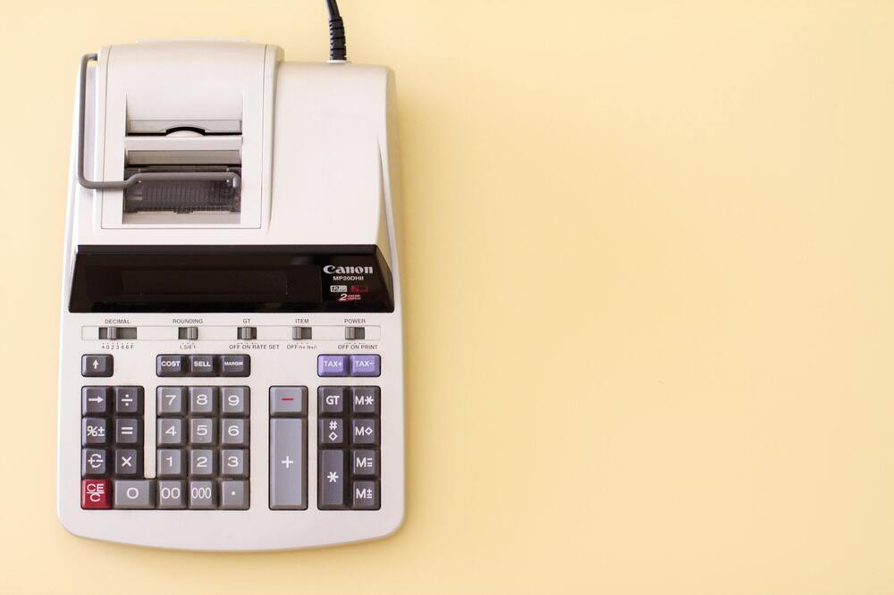 Calculator with receipt paper on light background