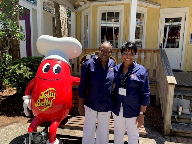 ceo and commissioner posing with jelly bean statue