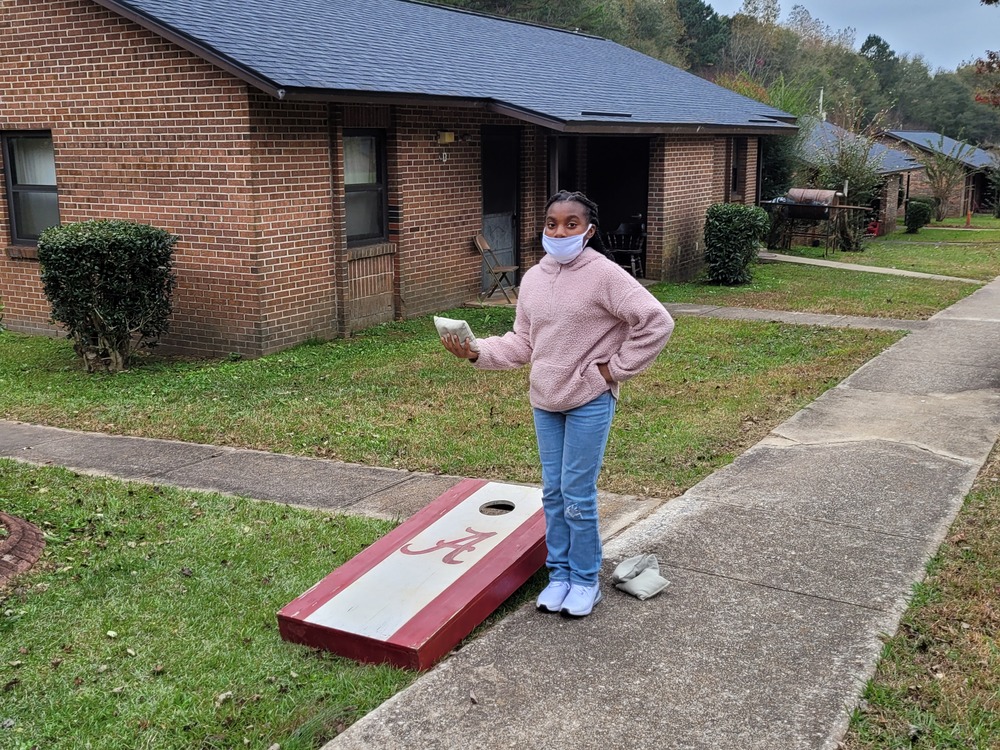 LHA Tailgate female youth resident playing corn hole