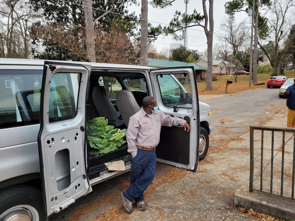 RHA Holiday Market man outside van door with vegetables