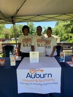 Three AHA Staff Members posing behind the Auburn Housing Authority vendor table