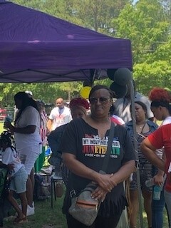 Juneteenth 2022 celebration female attendee standing looking