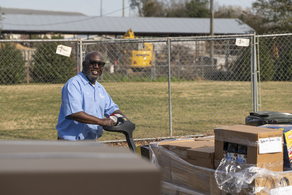 African american male smiling as he unloads food boxes