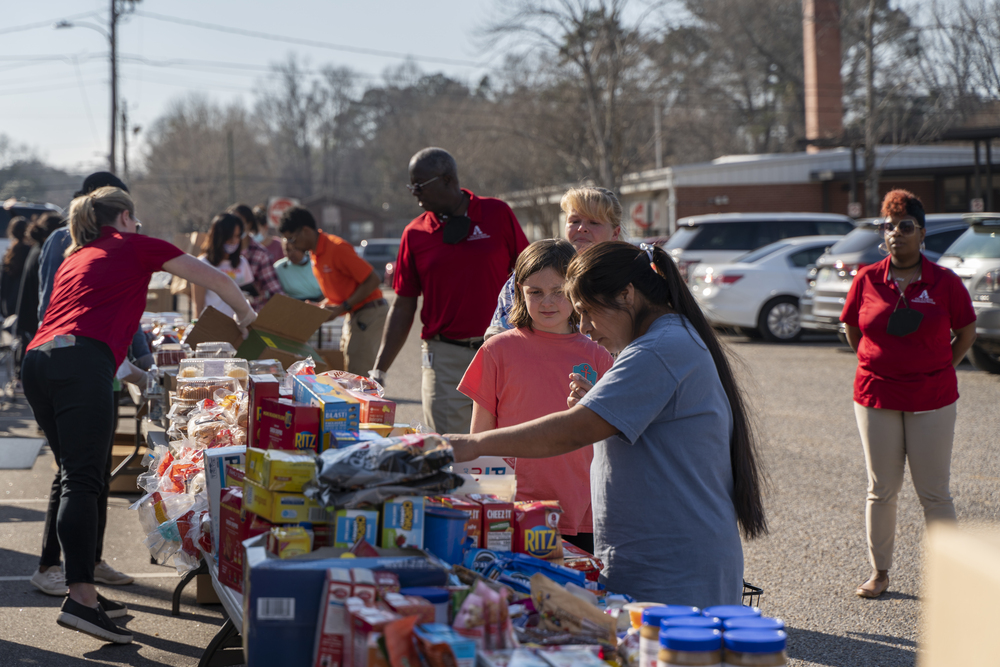 Residents and community members picking items from the food display tables