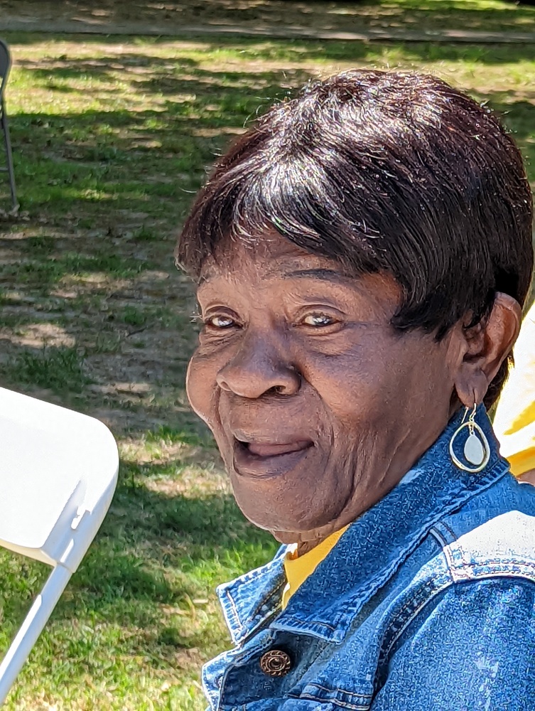 Older Female with short hair smiling in a blue jean jacket