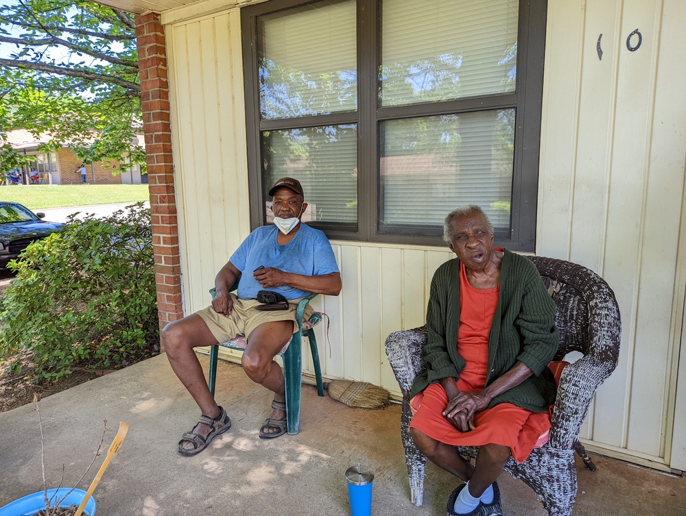 Two elderly residents sitting on porch of house