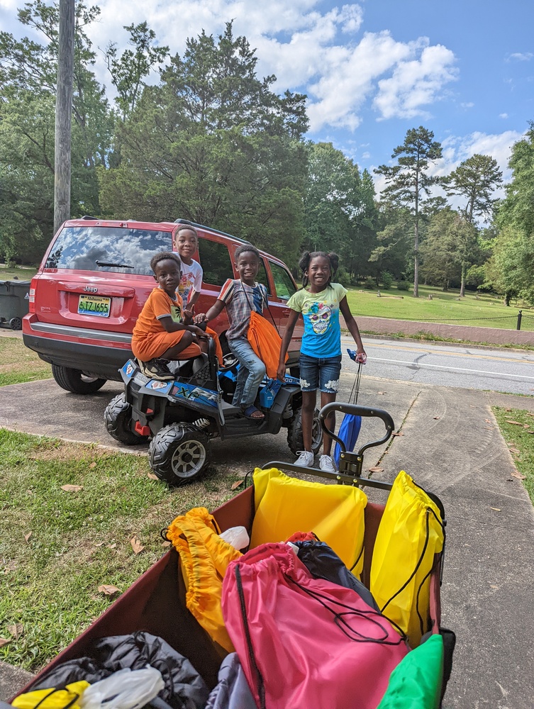 Youth residents gathered in parking lot near supplies