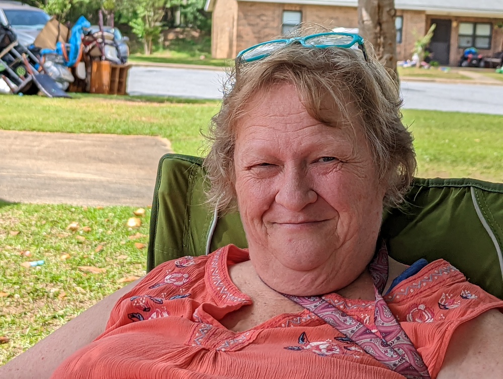 Older lady outside of event sitting in chair