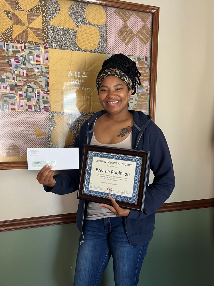 BreAsia Robinson Family Self Sufficiency Graduate holding certificate