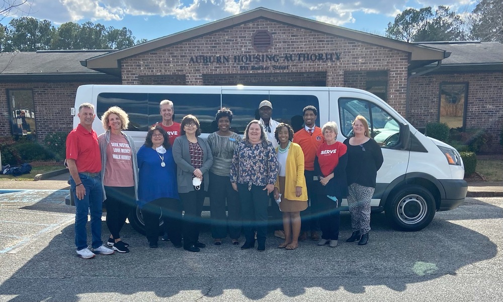 Staff members and Pastor Wren standing in front of new van