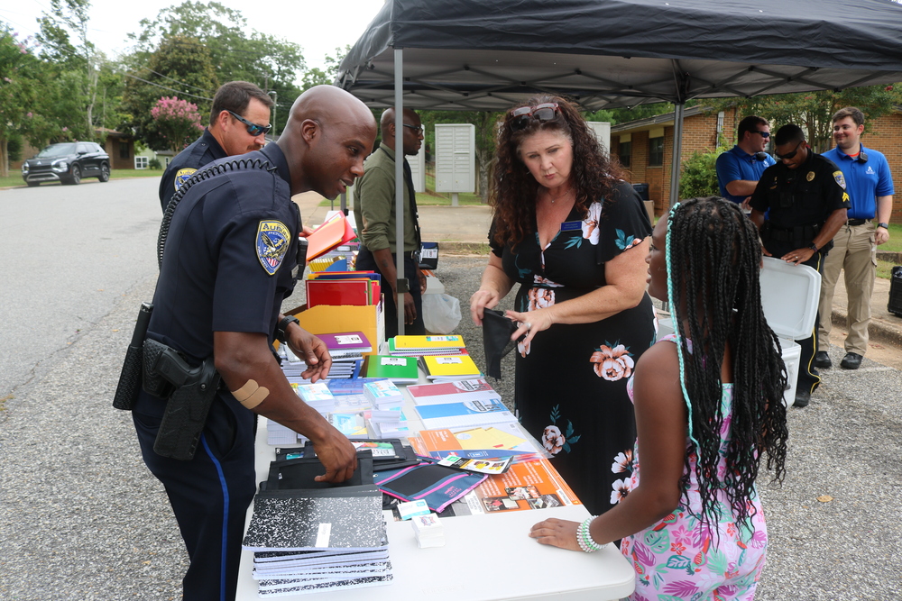 Auburn Police Officer providing supplies to youth at table