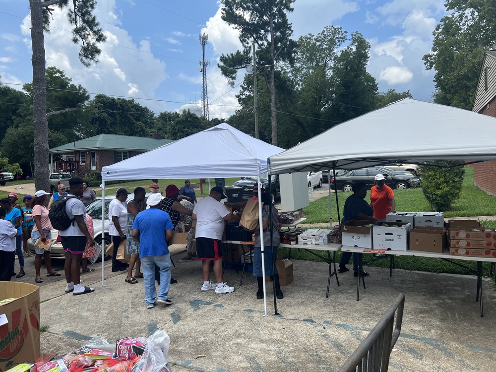 RHA Farmers Market attendees receiving food under outdoor tent