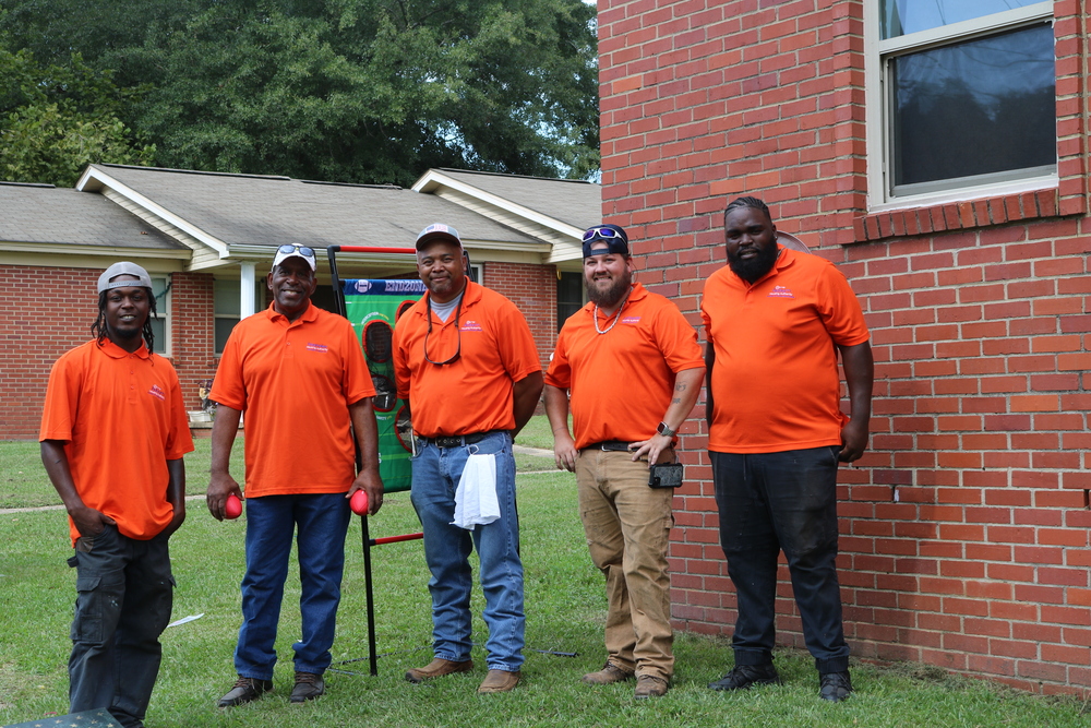 RHA Tailgate Maintenance men posed outside community buildings