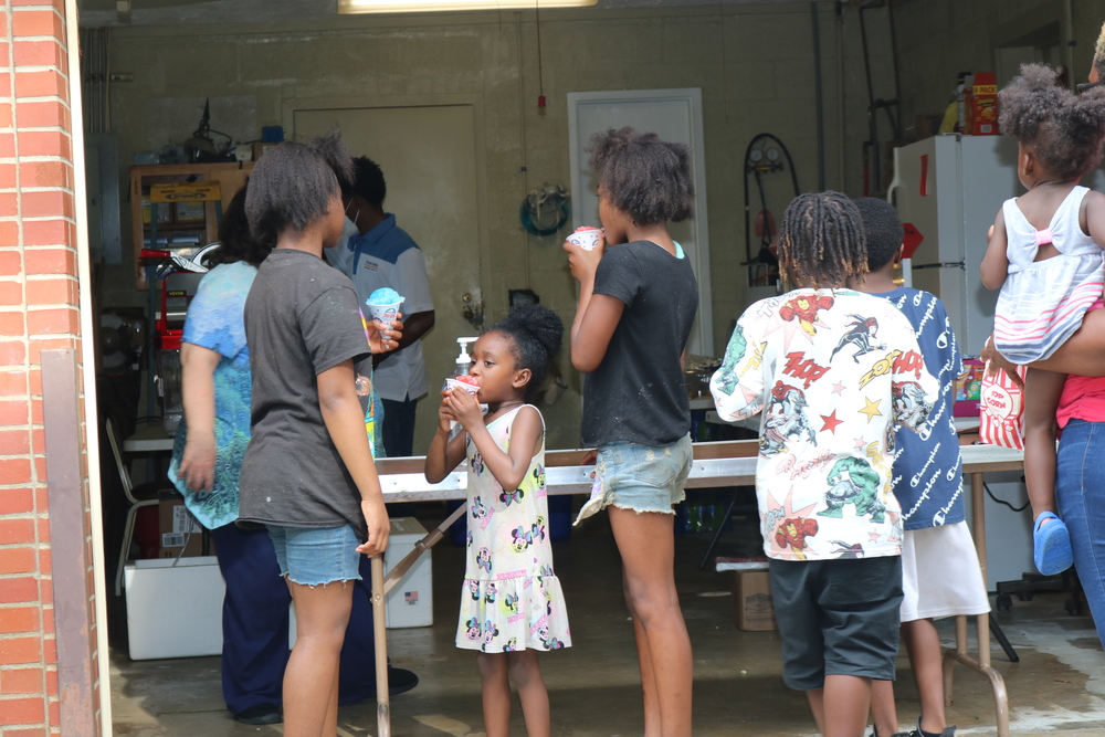 RHA Tailgate youth in line to get a snow cone from vendor table