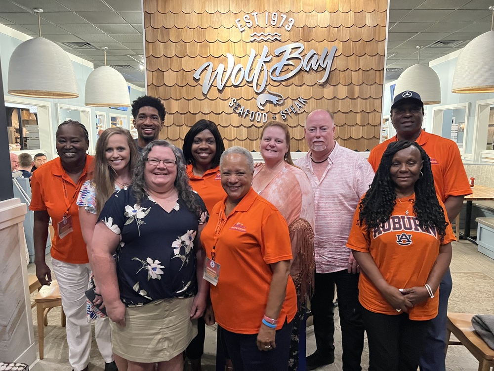 Board Members and Housing staff are posed in the entry way of a restaurant