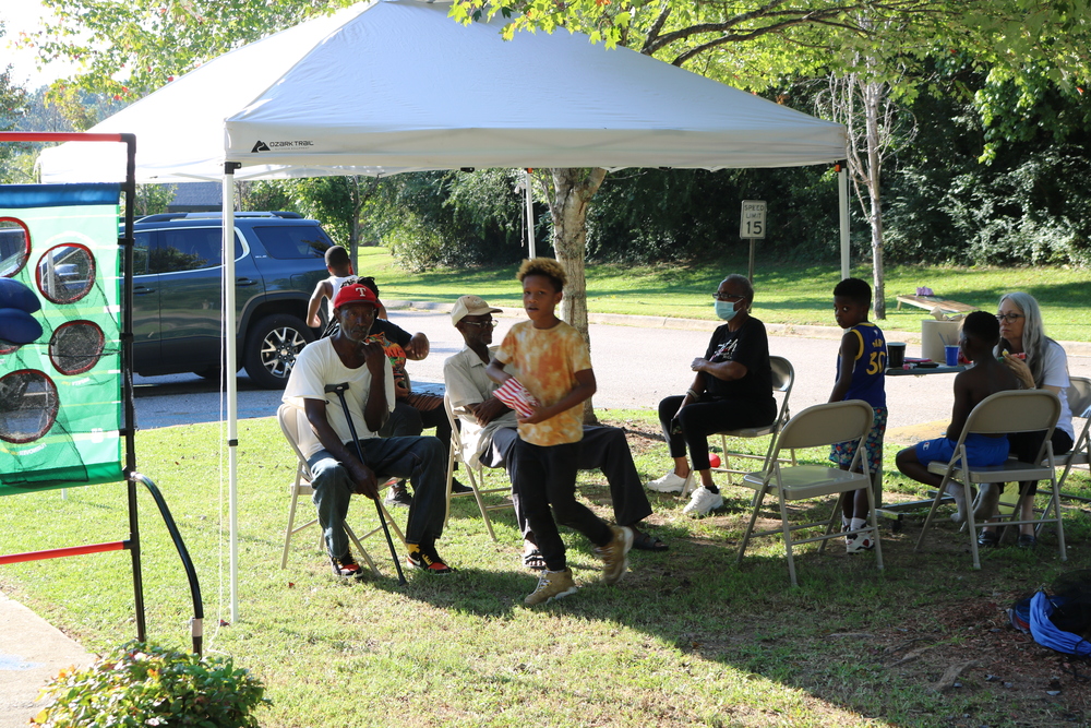 LaFayette Tailgate party residents sitting and talking under a tent