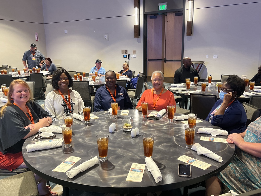 Members of staff and board sitting at a round table at the conference banquet