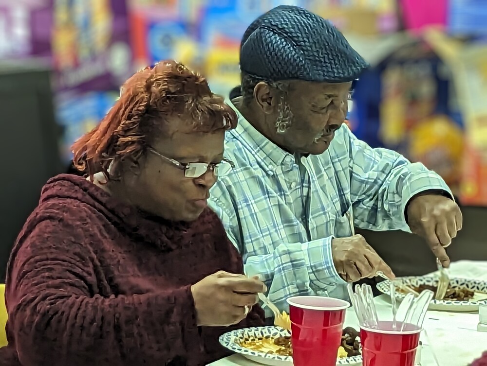 Older man and woman eating at wonderful wednesday event