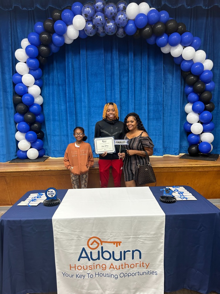 Graduate with family members at Auburn Housing Authority reception