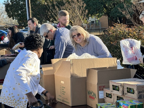 Christmas farmers market volunteers enjoying distributing food to elderly lady