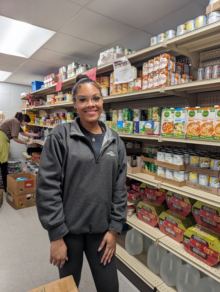 Food pantry volunteers placing items on shelf