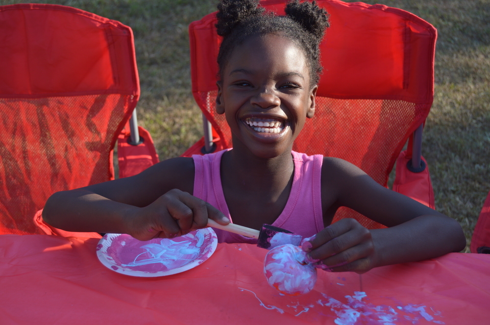 Kid painting pumpkin at National Night Out