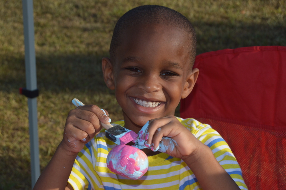 Kid painting pumpkin at National Night Out