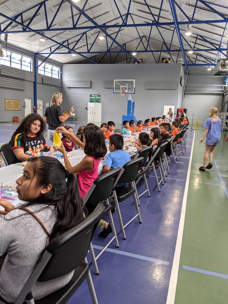 long table of kids eating at summer feeding