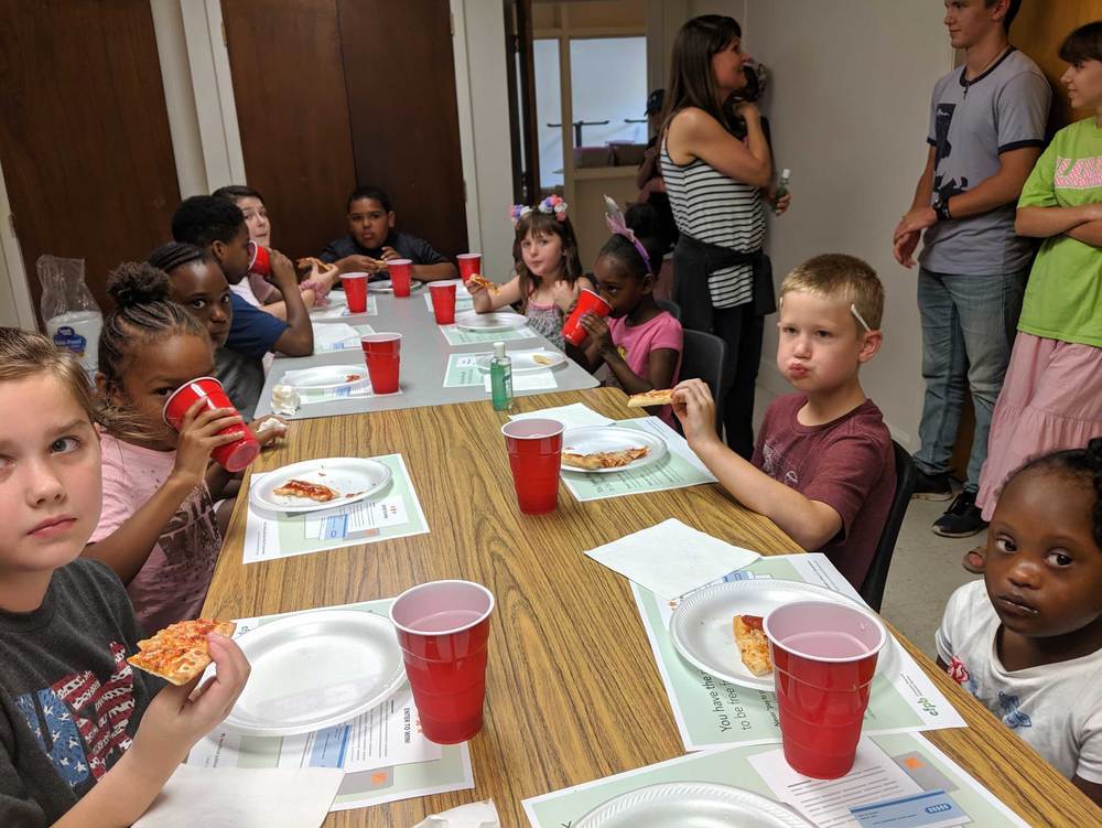 Table of kids eating at summer feeding