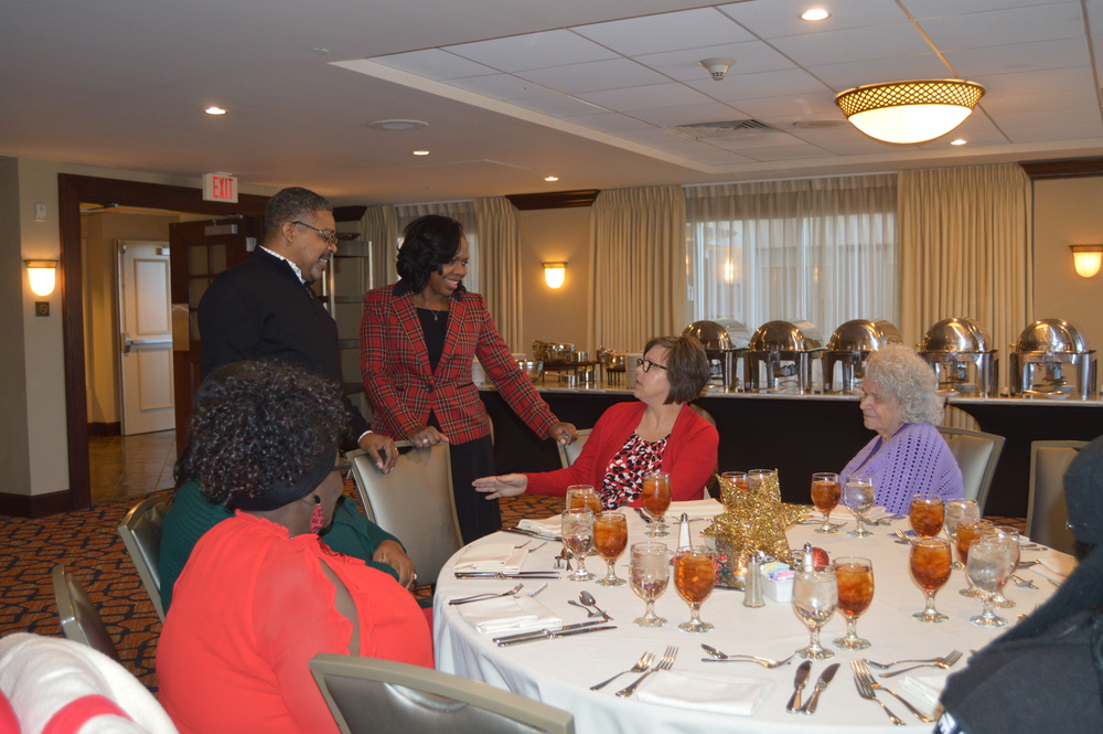 CEO Sharon Tolbert, husband, and employees at Christmas Luncheon