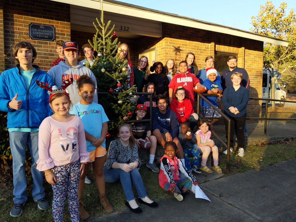 group of youth resident outside with decorated christmas tree
