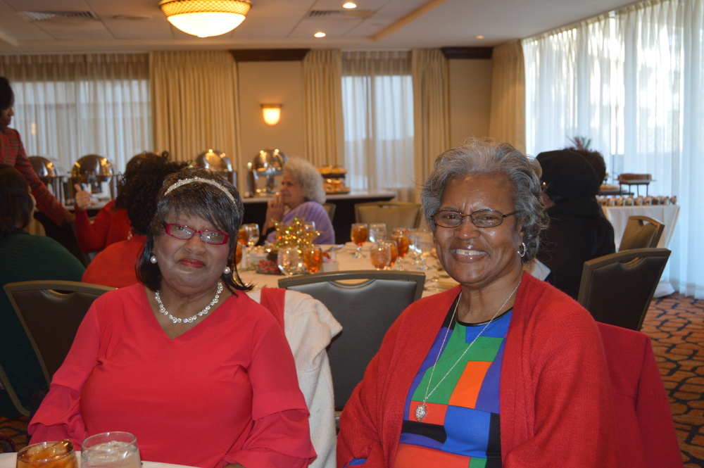 Employee Christmas Luncheon two female staff members smiling in red 