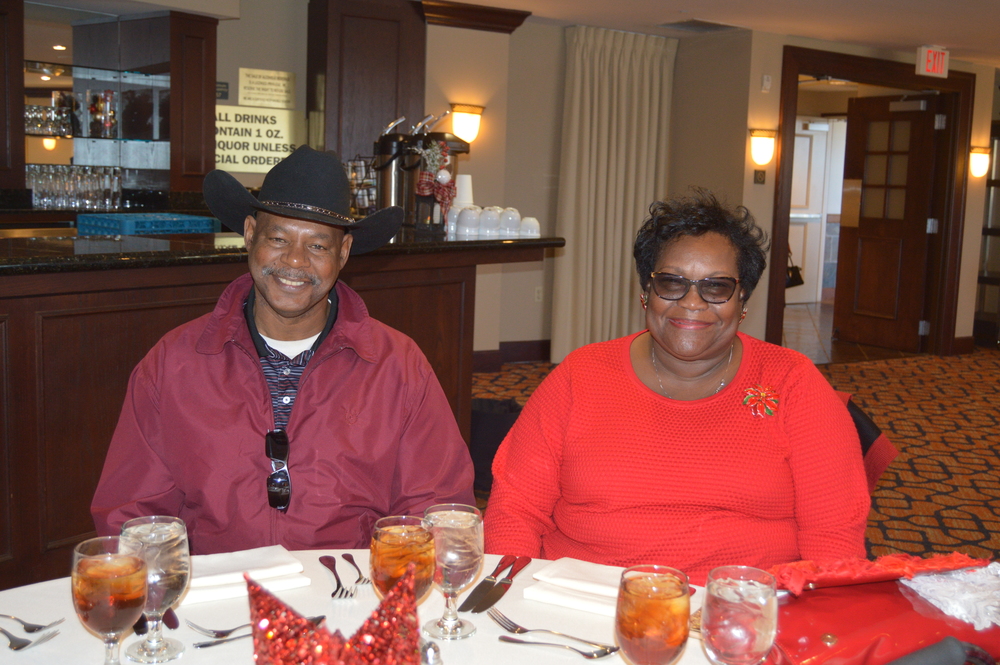 Male and female in red, male with a cowboy hat at table