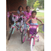 Bike giveaway recipients posing for a picture sitting on their new bikes.