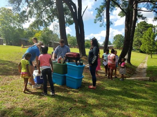 Volunteers and youth outside setting up for block party event. 