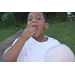 Youth resident smiling big while placing food in his mouth.