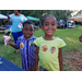 Youth residents smiling big with icee in hand and Auburn Police Department stickers on their shirts.