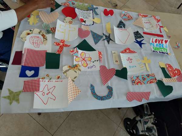 Table displaying designed quilt pieces by Senior Citizen on trip.