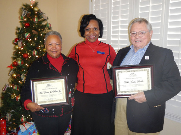 Commissioners Marguerite White and John Saidla holding certificates in loving memory of Clima White and Janice Saidla with CEO Sharon Tolbert. 