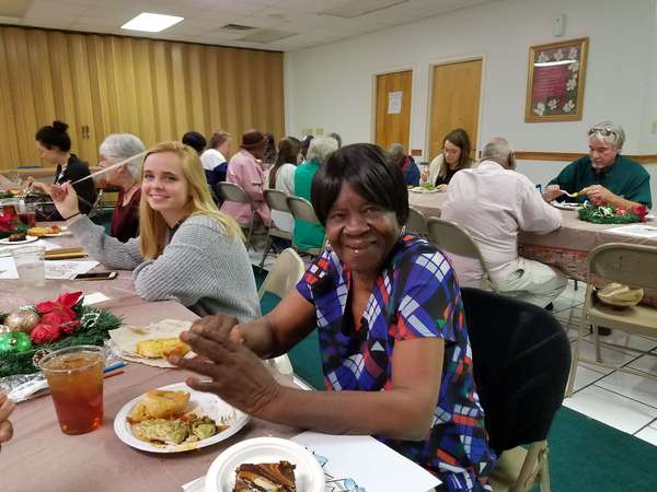 Senior Resident and a Auburn University Campus Kitchen student posing for picture at Christmas dinner.