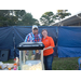 Male and female posing behind popcorn machine