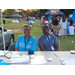 Male and female behind cellular phone vendor table smiling