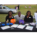 Three individuals posing behind a Auburn University vendor table