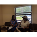 Two females holding paperwork and discussing homeownership