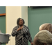 Woman in striped dress speaking from podium