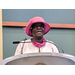 woman speaking from podium with pink hat