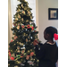 Young female putting an ornament on Christmas tree