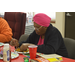 Older resident with scarf working on her Christmas tree craft