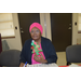 Older resident with bonnet holding her Christmas tree craft